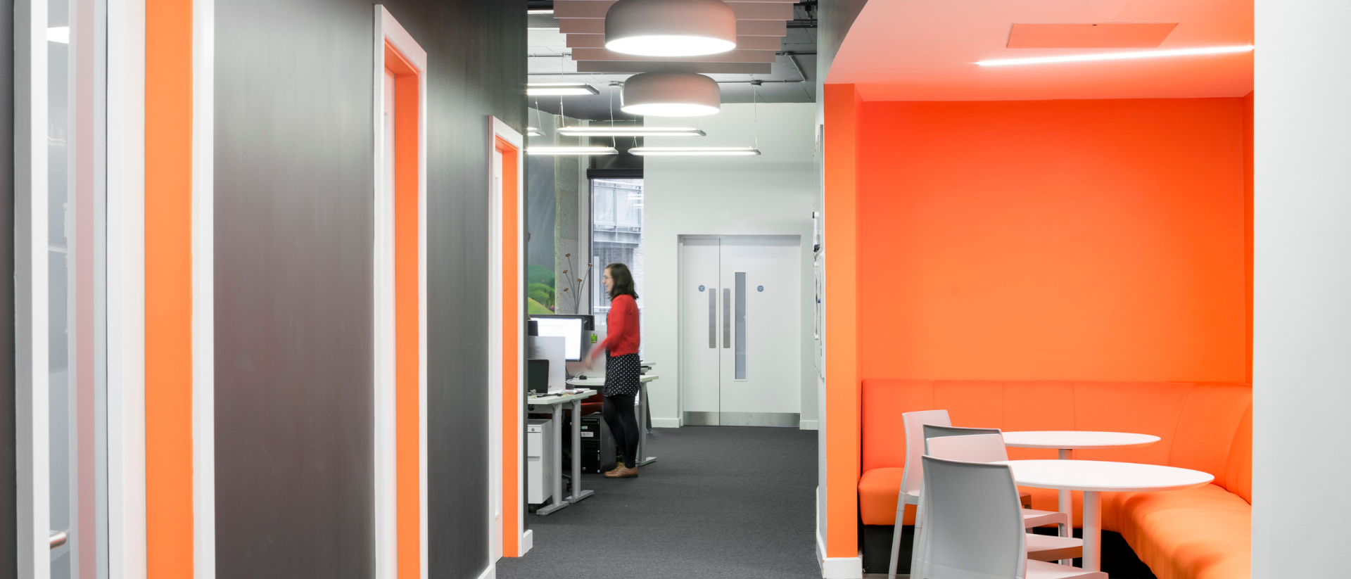 Bright hallway with orange accents and glass doors.