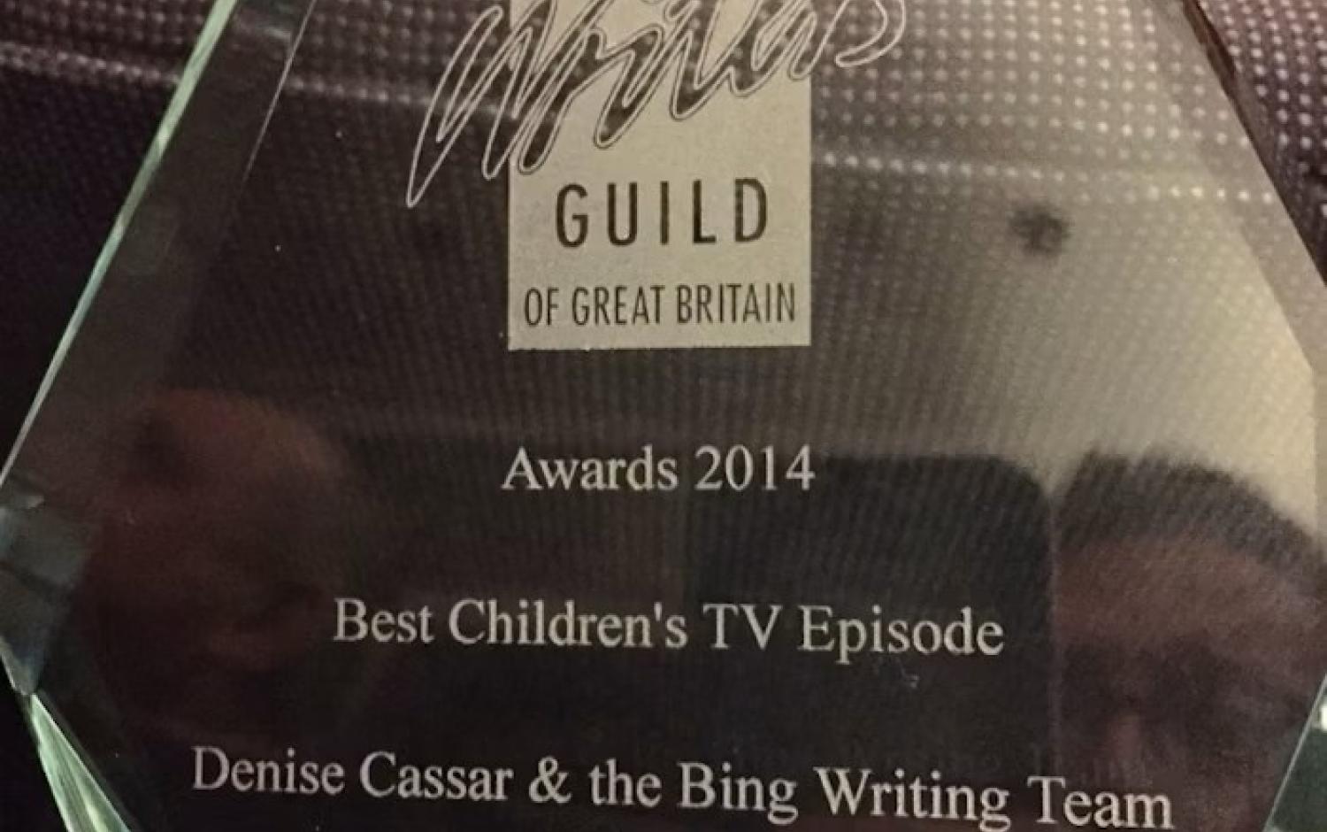 A glass award plaque from The Writers' Guild of Great Britain recognizing “Best Children's TV Episode” in 2014 for “Bing: Bye Bye” by Denise Cassar and the Bing writing team.