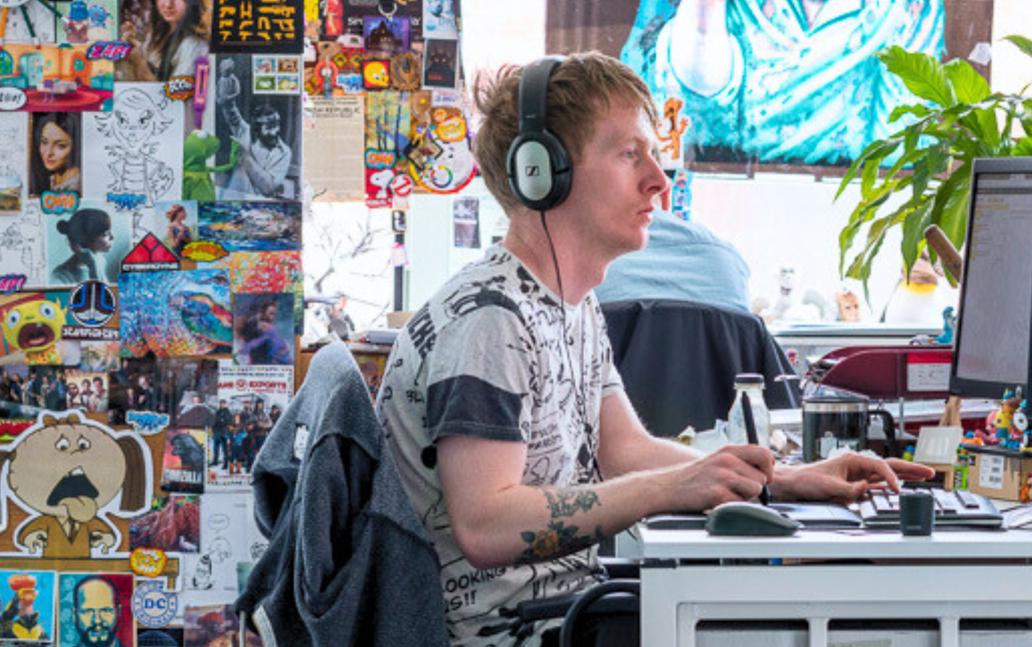 Desk filled with creative materials and colorful wall decorations.