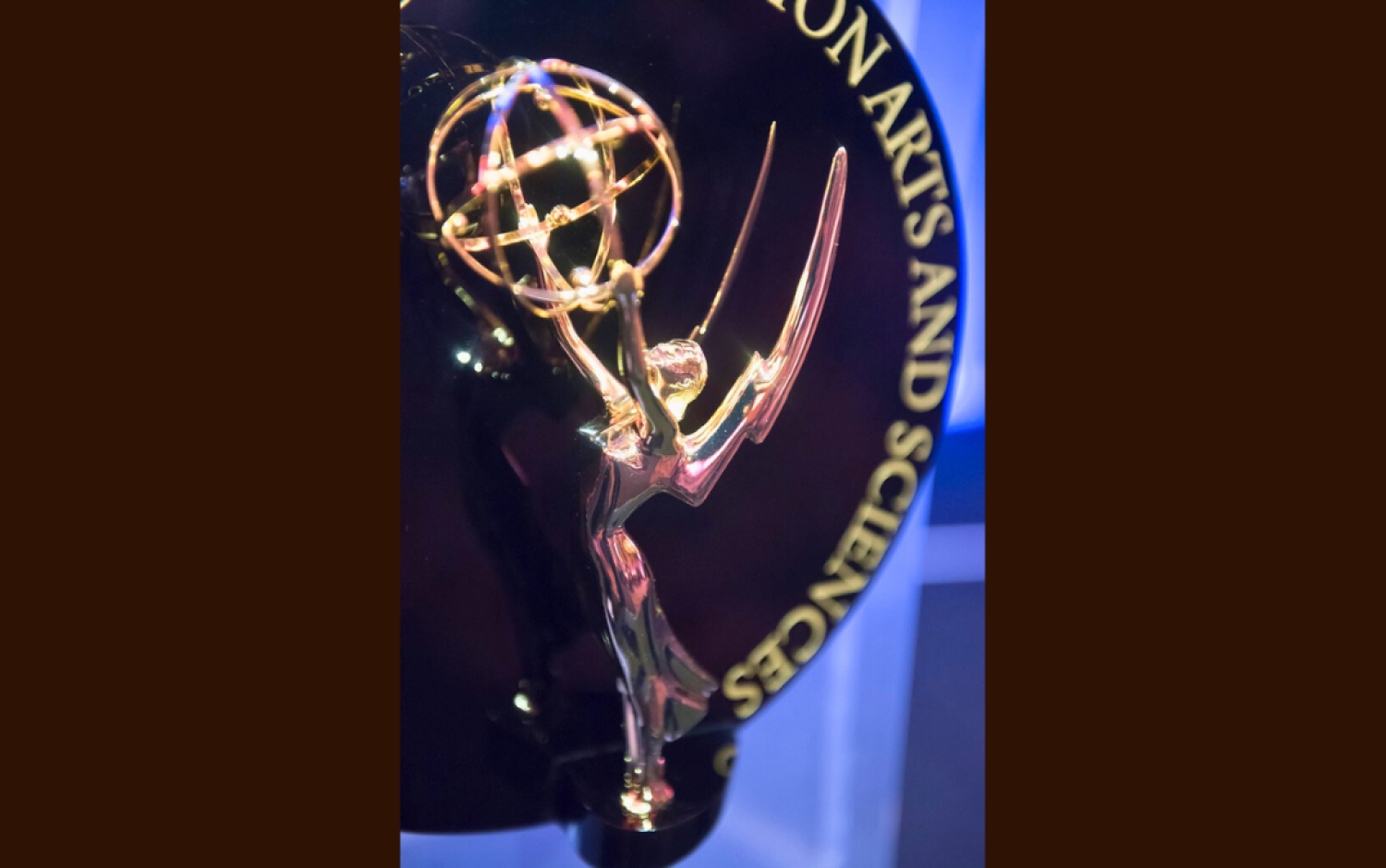 Close-up of an Emmy Award trophy against a dark background with engraved text.
