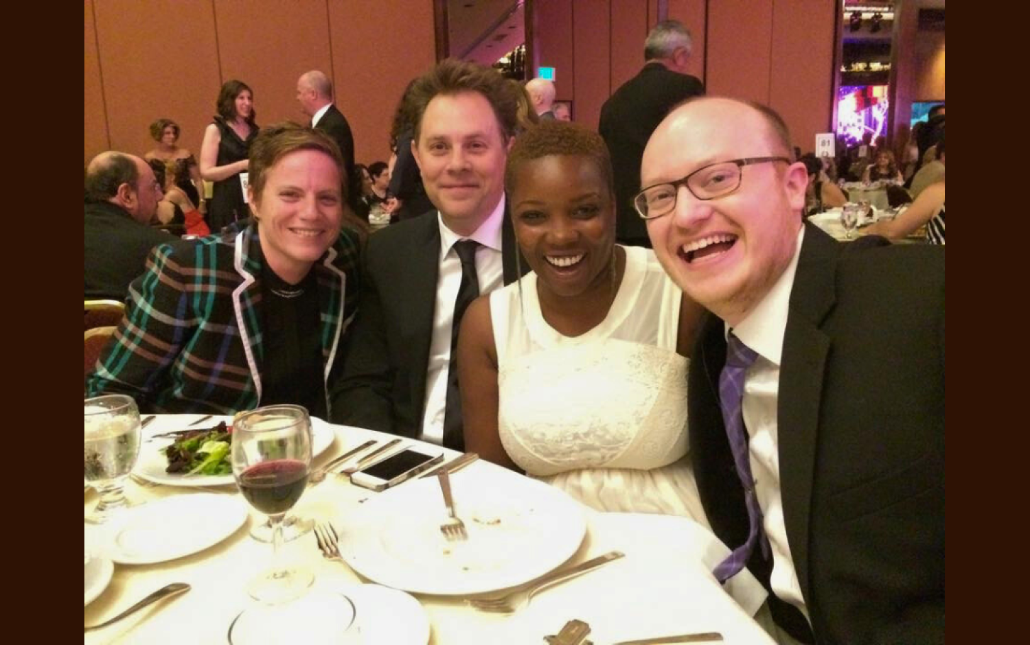 Group seated at a banquet table during an awards ceremony.