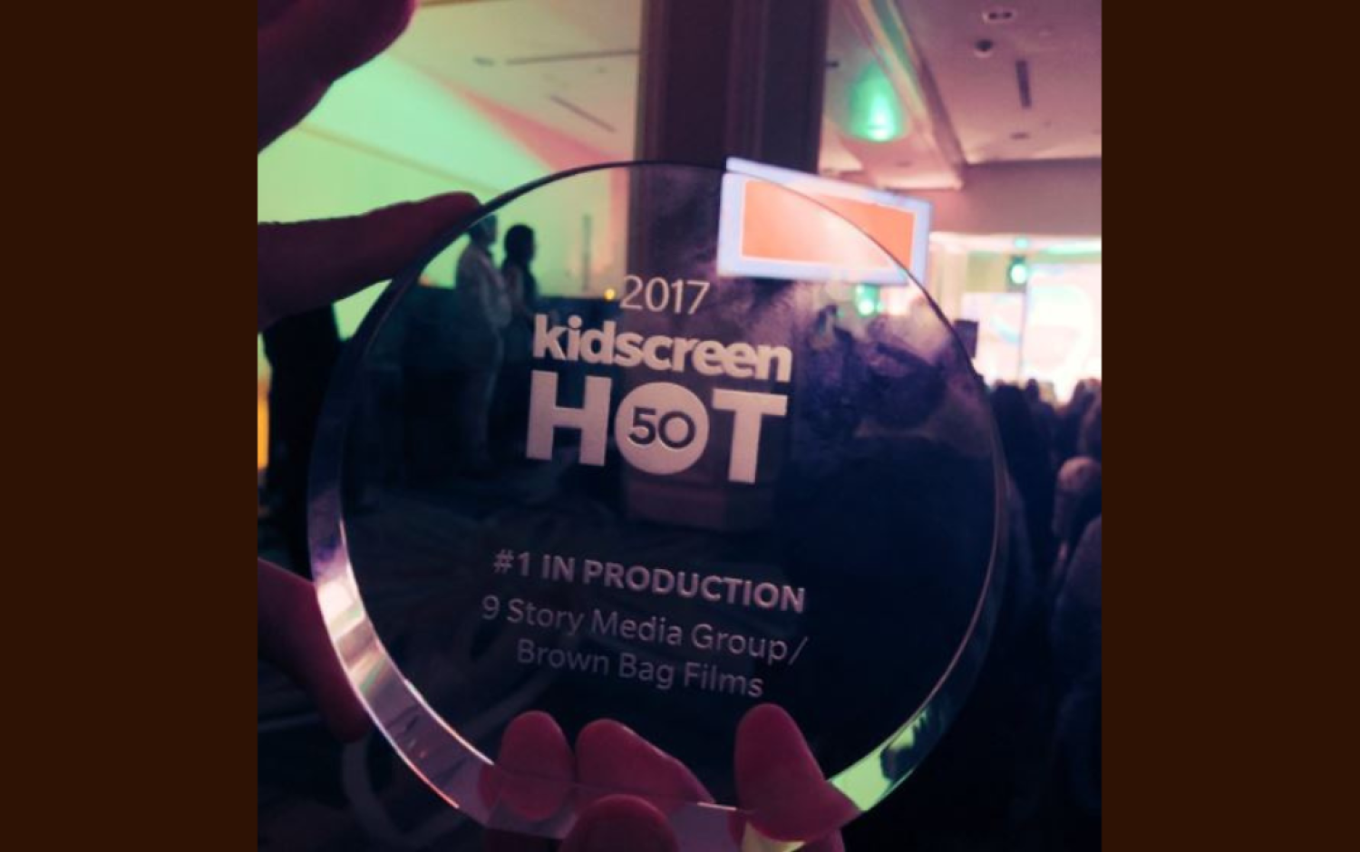 Close-up of a clear circular award engraved “2017 Kidscreen Hot 50 – #1 in Production, 9 Story Media Group/Brown Bag Films.”