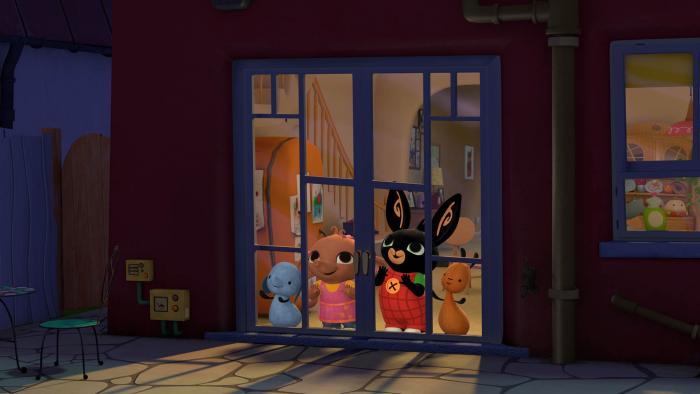 Bing and friends standing behind glass doors looking out into the night