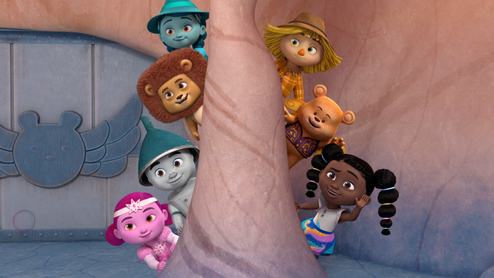 Dee and her friends peeking out from behind a rock pillar